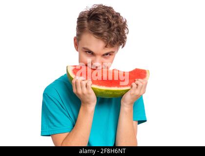 Portrait of teen boy eating ripe juicy watermelon and smiling. Cute young teenager with slice healthy watermelon, isolated on white background Stock Photo