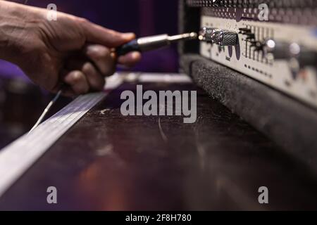 Jack audio connector being plugged into a socket on an audio device for music, audio. Stock Photo