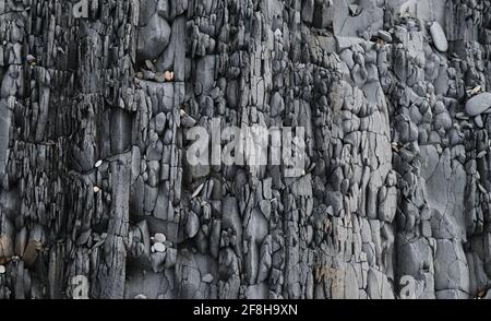 Gray striped rock. Texture natural minimalistic stone background. Parallel striped lines of mountain close up. Stock Photo