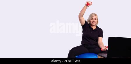 Banner, long format on gray background. Senior woman workout in front of pc laptop. Old person online internet exercise training, at home sport Stock Photo