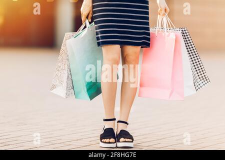Let's go shopping. woman holds colorful shopping bags on the street against the background of a shopping center. Fashion Stock Photo