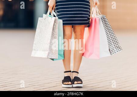 Let's go shopping. woman holds colorful shopping bags on the street against the background of a shopping center. Fashion Stock Photo