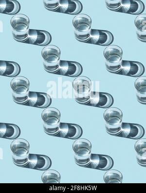 Pattern from glasses with water on a blue background. Ecological concept, space for text. Stock Photo
