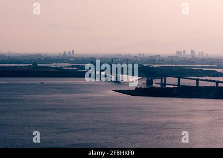A selective focus shot of the Tokyo Gate Bridge in Tokyo Bay from a helicopter at sunset Stock Photo