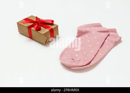 Pair of pink women socks and a gift box on the white background, Top view. Stock Photo