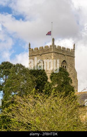 Flag flying at half-mast on Dersingham church as a sign of respect during the period of public mourning for the death of the Duke of Edinburgh. Stock Photo