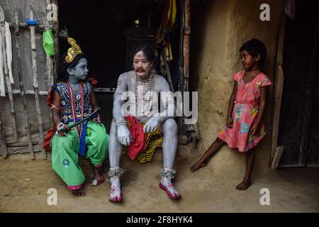 Bardhaman, India. 13th Apr, 2021. A man and his children seen at home after getting their bodies painted during the Gajan festival. Gajan is a Hindu festival celebrated mostly in West Bengal as well as southern part of Bangladesh. The festival is associated to the devotion of Lord Shiva. People celebrate by performing rituals such as face painting and cosplaying. Devotees dress up as Hindu mythological characters and perform various mythological stories door to door. (Photo by Tamal Shee/SOPA Images/Sipa USA) Credit: Sipa USA/Alamy Live News Stock Photo