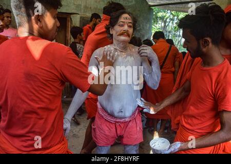 Bardhaman, India. 13th Apr, 2021. Devotees help paint another devotee's body during the Gajan festival. Gajan is a Hindu festival celebrated mostly in West Bengal as well as southern part of Bangladesh. The festival is associated to the devotion of Lord Shiva. People celebrate by performing rituals such as face painting and cosplaying. Devotees dress up as Hindu mythological characters and perform various mythological stories door to door. (Photo by Tamal Shee/SOPA Images/Sipa USA) Credit: Sipa USA/Alamy Live News Stock Photo