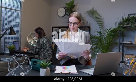 Manager irritated sad angry mad businesswoman accountant after analyzing financial papers in office Stock Photo