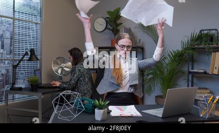 Manager irritated sad angry mad after analyzing financial papers in office throwing office documents Stock Photo
