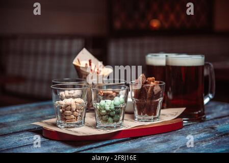 snacks to beer in glass glasses on a wooden table. Stock Photo