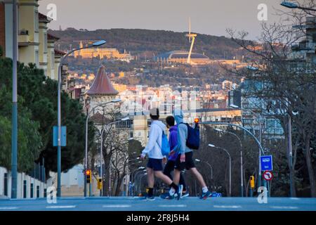 Group of boys crossing street while watching Montjuic mountain. Barcelona, Catalonia, Spain. Stock Photo