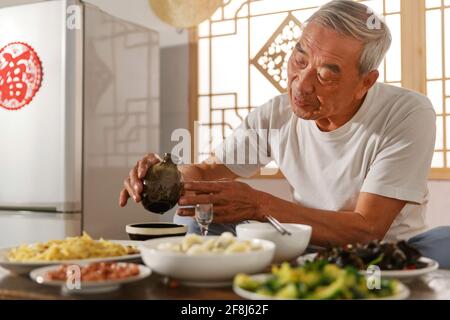 Old people sitting at home eating drinking Stock Photo
