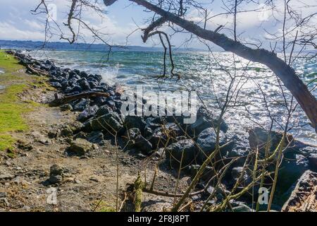 Back rocks lin the shore on a windy day at Satlwater State Park in ...