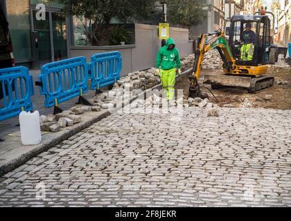 Workers creating cobblestone road Stock Photo