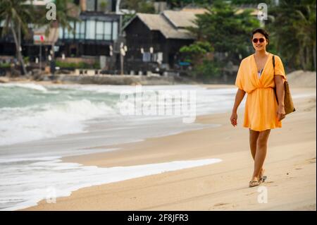 Woman walking along the beach on the tropical island of Koh Phangan Stock Photo