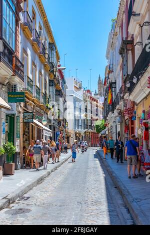 SEVILLA, SPAIN, JUNE 25, 2019: People are strolling on a street in Sevilla, Spain Stock Photo