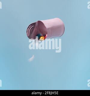 Colorful easter eggs and feathers in a pink floating can against Stock Photo