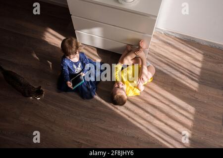 Children are bored at home. Play With Digital Device Stock Photo