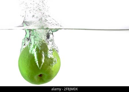 juicy green apple falls into the water on a white background, place under the text Stock Photo