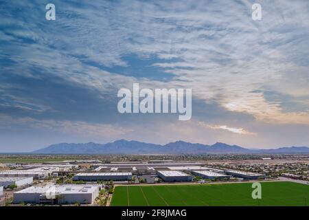 Aerial panoramic view of goods warehouse logistics center in industrial city zone near of neighbourhood suburban homes in Avondale residential area Stock Photo