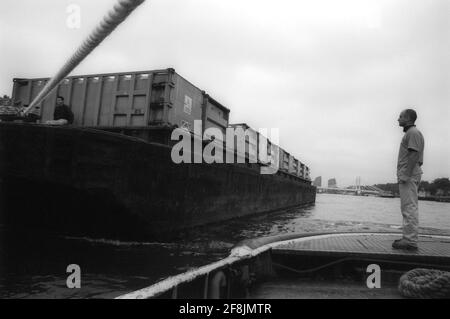 Lightermen of the River Thames using ropes to secure the barges for towing Stock Photo