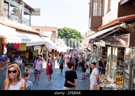 A street in Rhodes Old City busy with tourists relaxing amongst the souvenir  during the holiday season Stock Photo