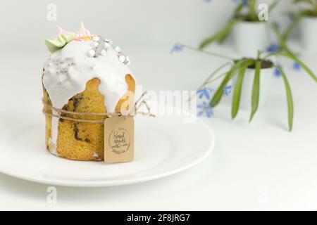 Easter cake on a white plate tied with twine on a background of spring flowers Stock Photo