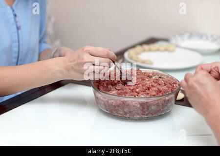 Two women are cooking pelmeni at home Stock Photo