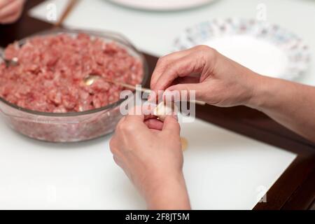 A housewife is cooking dumplings at home Stock Photo
