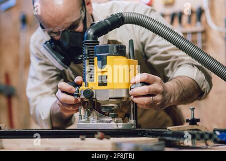 detail of a carpenter using a router  machine inside his workshop Stock Photo