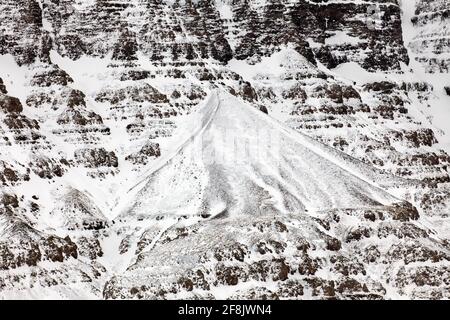 Snow covered talus cone and scree, stony deposit at base of mountain slope in winter at Snaefellsnes, western Iceland Stock Photo