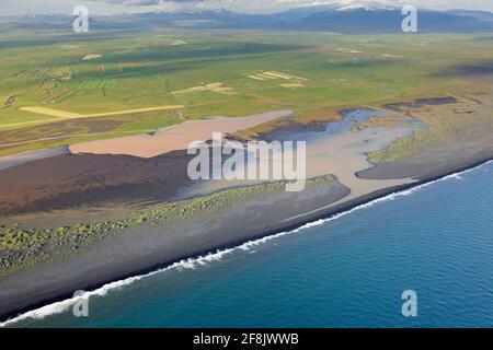 Aerial view over Landeyjarsandur showing beach with black volcanic sand and brown water laden with sediment flowing in sea in summer, Iceland Stock Photo