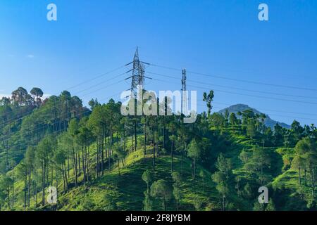 Transmission tower or pylon a steel lattice tower support overhead power line. Electricity transmission in mountain regions through complicated geogra Stock Photo