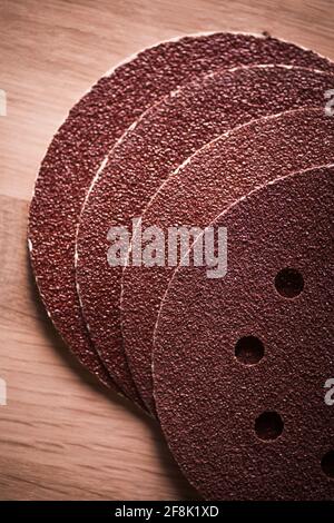 Close up shot of some sandpaper round pieces on a wooden table. Stock Photo