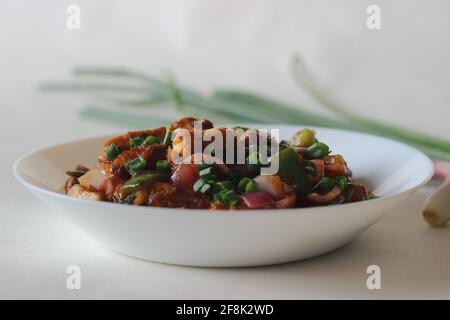 Air fried cottage cheese cubes and baby corn prepared with chilli sauce. It is an Indo Chinese dish, locally known as chilly paneer with baby corn. Sh Stock Photo