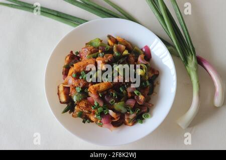 Air fried cottage cheese cubes and baby corn prepared with chilli sauce. It is an Indo Chinese dish, locally known as chilly paneer with baby corn. Sh Stock Photo