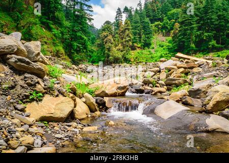 View enroute to Prashar Lake trekk trail through small waterfall rivulet. It is located at a height of 2730 m above sea level surrounded by lesser him Stock Photo