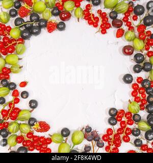 Fresh ripe berries, cherries, raspberries, currants and gooseberries on white background in form of frame. Place label in center. Summer berries, harv Stock Photo