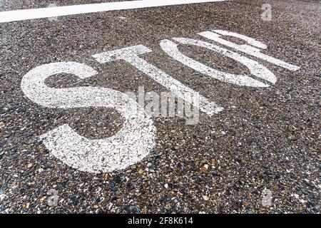 STOP a large inscription on the asphalt in full screen. Stock Photo