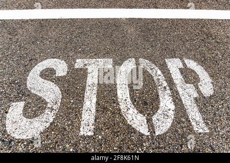 STOP a large inscription on the asphalt in full screen. Stock Photo