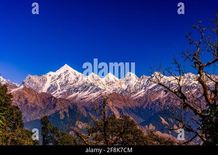 Mesmerizing view of Snow cladded Panchchuli peaks falls in great Himalayan mountain range and alpine grass meadows at small hamlet Munsiyari, Kumaon r Stock Photo