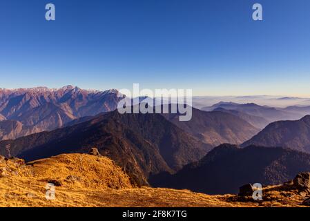 This is the view enroute to Khalia top trek trail through Himalayas autumn alpine grass landscape at Munsiyari. Khalia top is at an altitude of 3500m Stock Photo