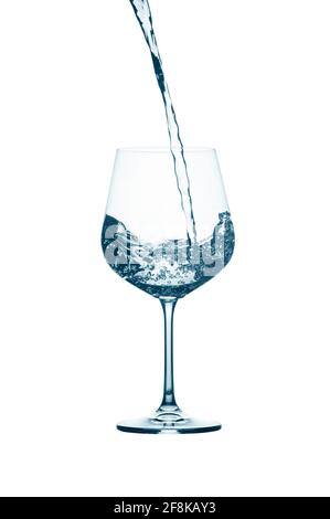 Pouring water into a glass isolated on white background. Stock Photo