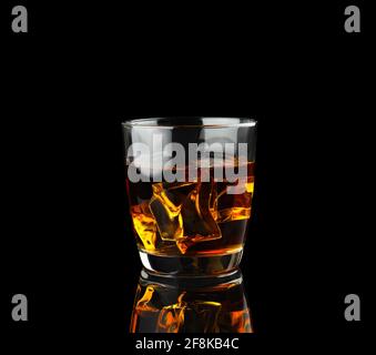 Glass of whiskey with ice isolated on black background Stock Photo