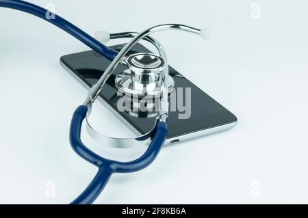 Stethoscope on the smartphone on a grey background. Phone repair and service concept. Concept a health of device. Stock Photo