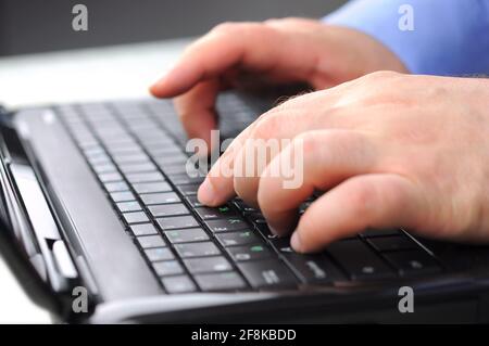 Male hands typing on a laptop keyboard. Programmer, Mobile Application Designers, Web Designer working at office. Stock Photo