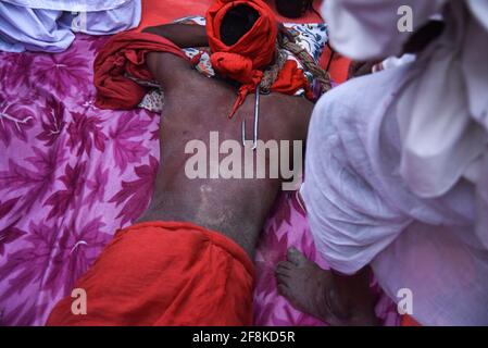 Guwahati, Assam, India. 14th Apr, 2021. Hindu devotee pierced with iron hook, during Charak Puja festival amid COVID-19 Coronavirus pandemic at a village in Barpeta district of Assam. Charak Puja is a Hindu folk festival in honour of the god Shiva. It's held in Indian state of West Bengal and southern Bangladesh on the last day of the month of Chaitra, at midnight. Credit: David Talukdar/ZUMA Wire/Alamy Live News Stock Photo