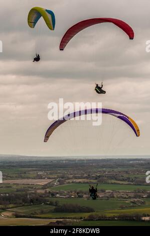 Bo Peep, Alciston, Lewes, East Sussex, UK. 14th Apr, 2021. A bright start to the day with cloud increasing in the afternoon. Cold wind from the North East brings paraglider pilots to Bo Peep on the South Downs Way above the glorious Sussex countryside. Credit: David Burr/Alamy Live News Stock Photo