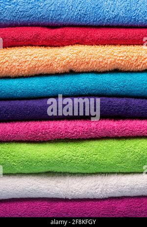 Close-up with a stack of multicolored soft towels. Full-frame with a pile of folded towels. Stock Photo